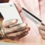 A developer holding a smartphone and a credit card checks the saga pattern on visible on the device.